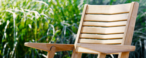A close-up of a wooden chair showcasing its smooth, natural finish, highlighting the care and quality typical of teak products.