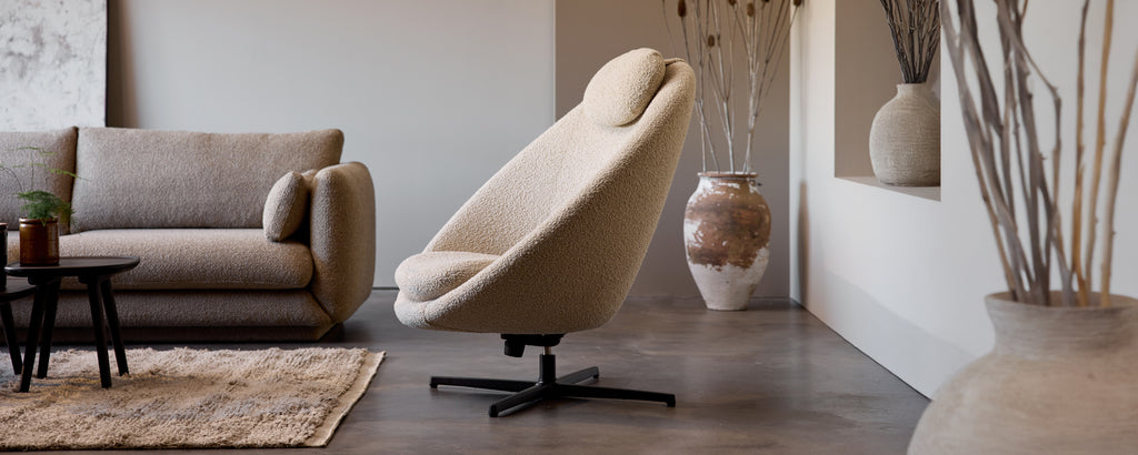 Beige swivel chair and grey sofa in a modern lounge setting.