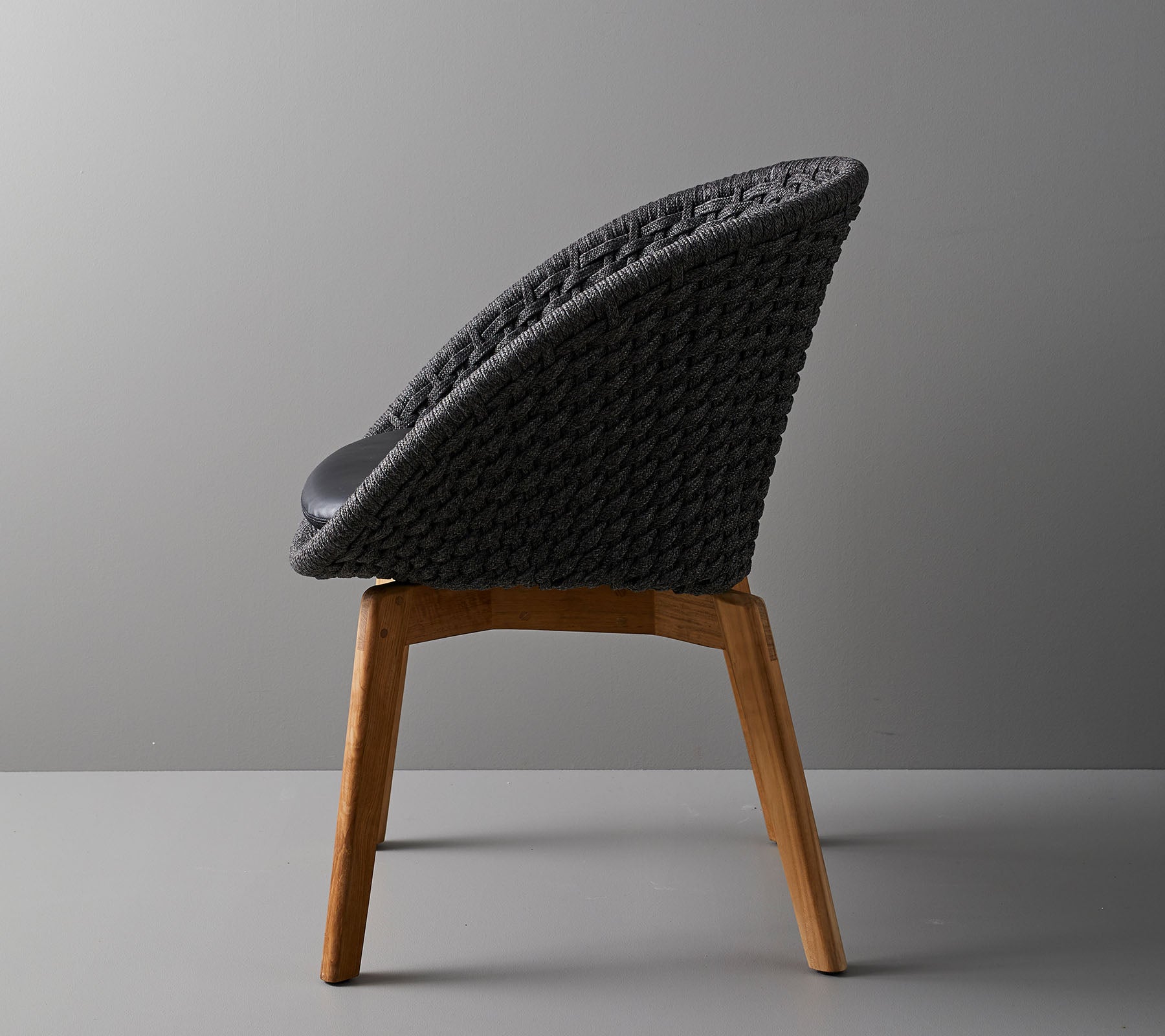 Stylish chair with a woven backrest and wooden legs, offering a modern design ideal for contemporary spaces.