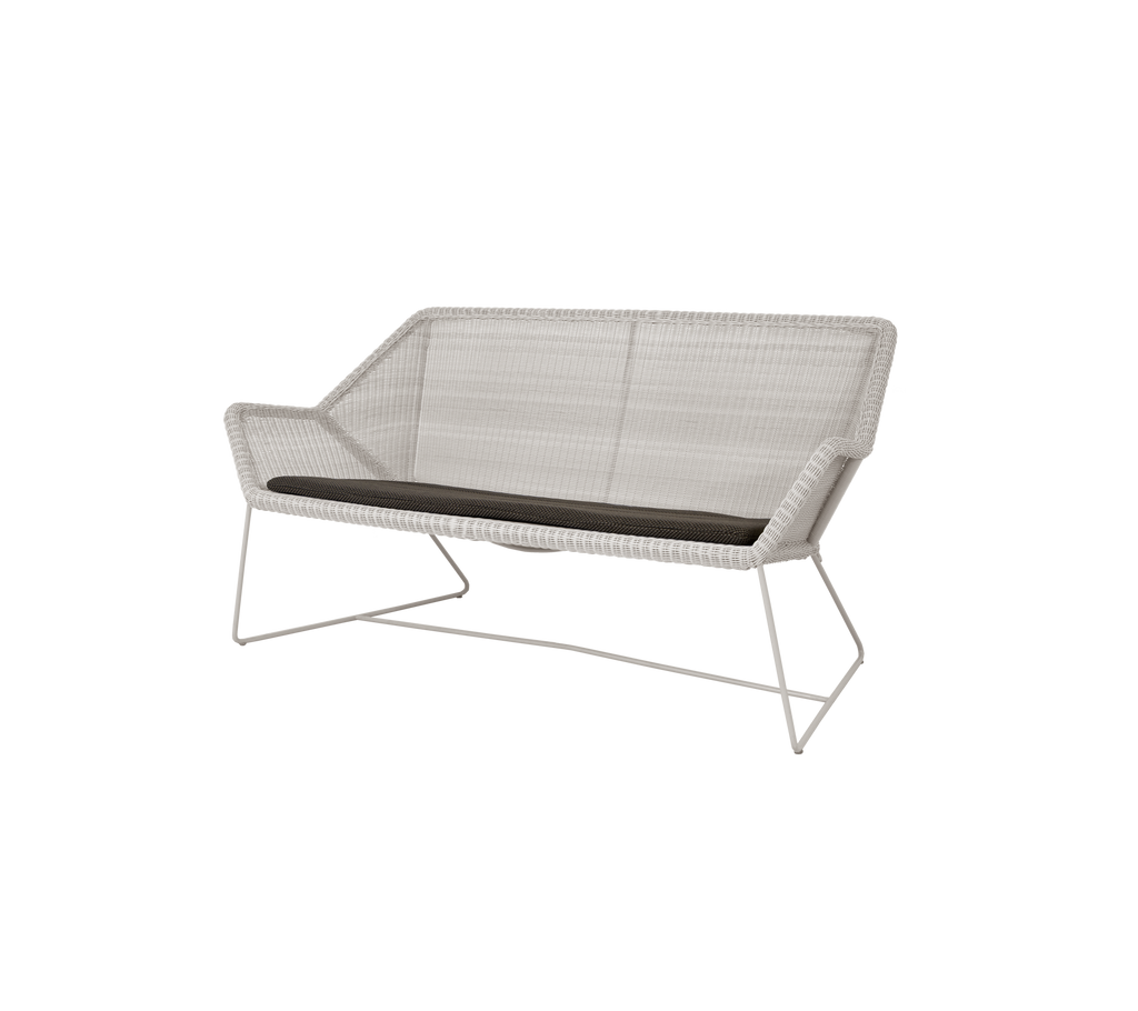 Modern sand loveseat with a dark grey cushion.