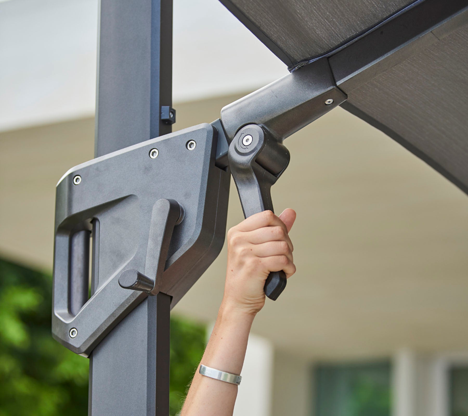 Hand adjusting a shading mechanism, showcasing a sleek design for optimal light control and convenience.