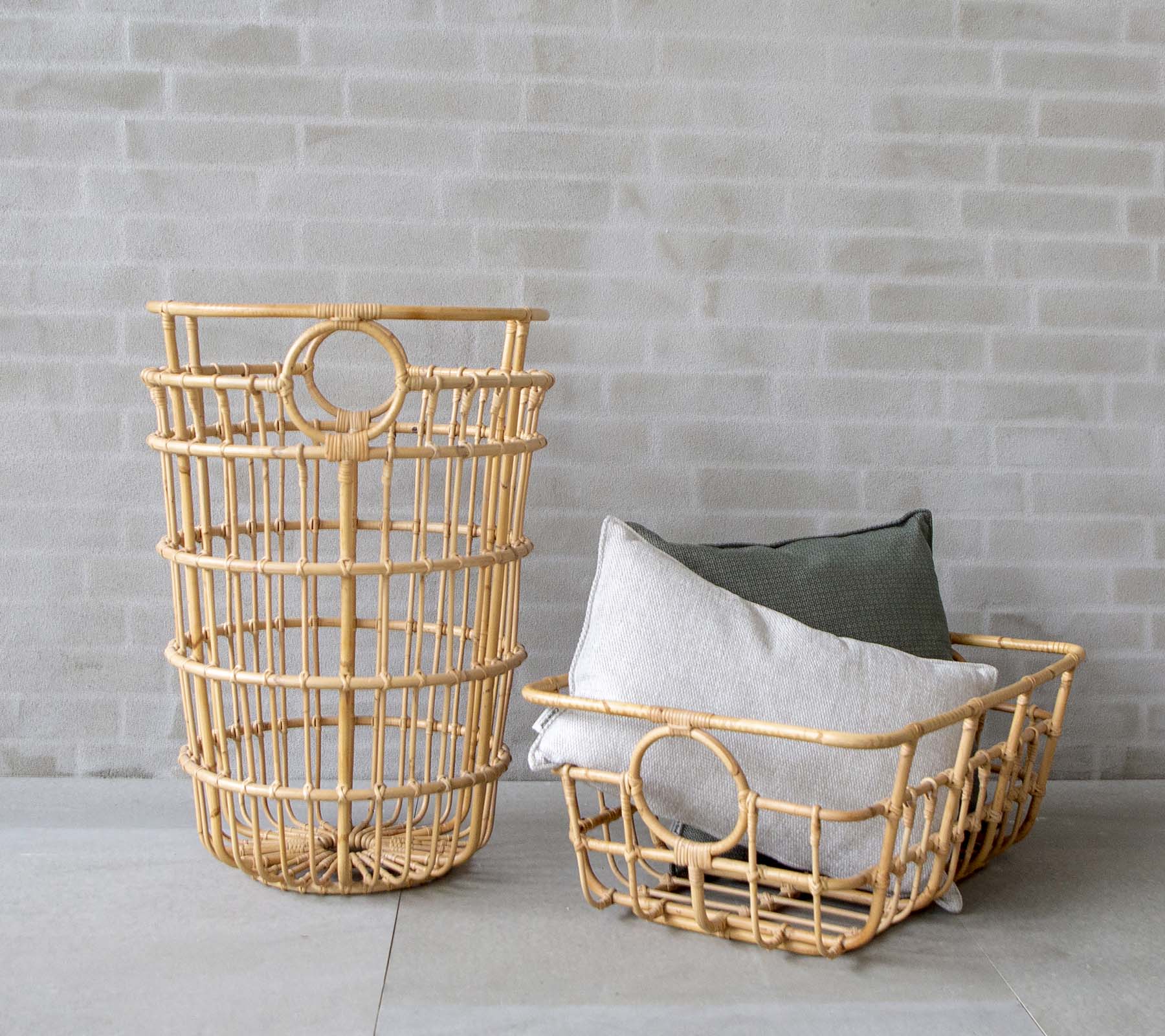 Modern woven baskets with grey and green cushions in a minimalist setting.