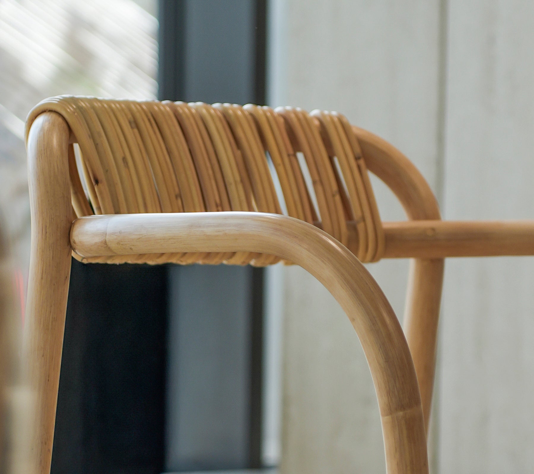 Close-up of a modern bamboo chair with a unique woven backrest.