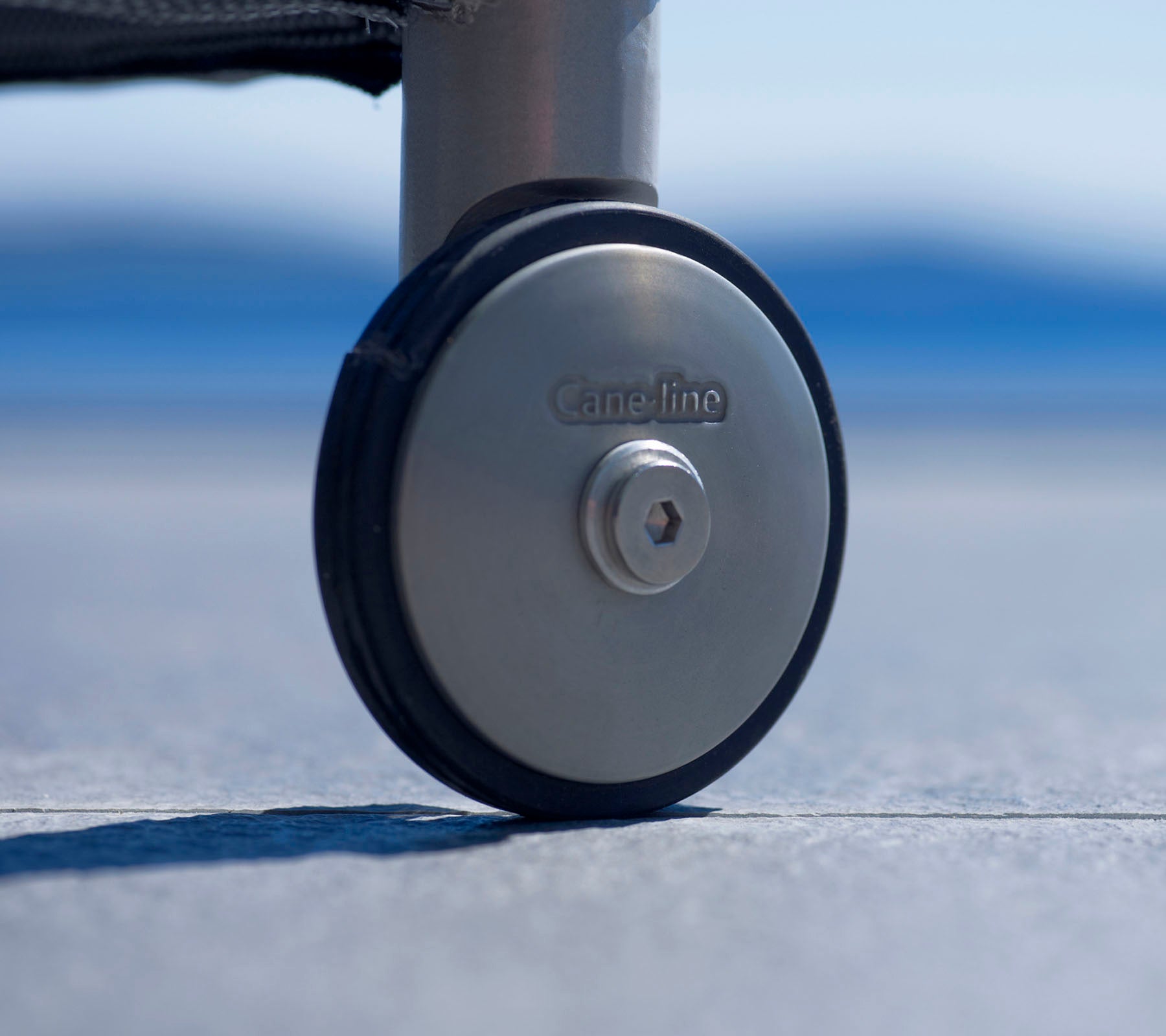 Close-up of a durable caster wheel with a metallic finish and a logo, designed for easy mobility and stability on various surfaces.