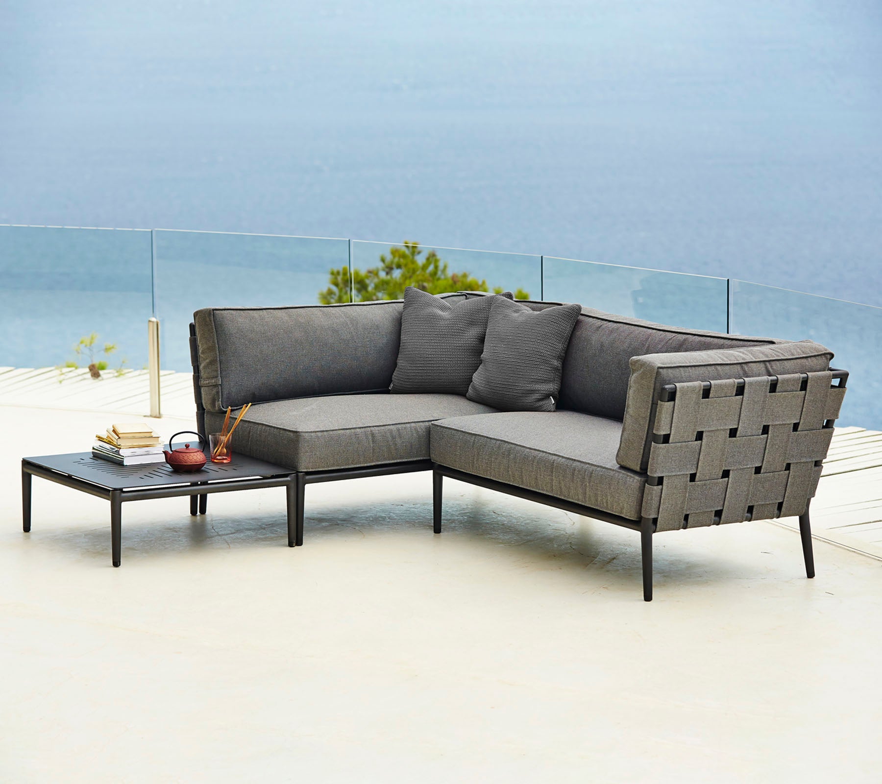 Stylish outdoor sectional sofa with comfortable cushions and a matching side table, perfect for relaxation and enjoyment.