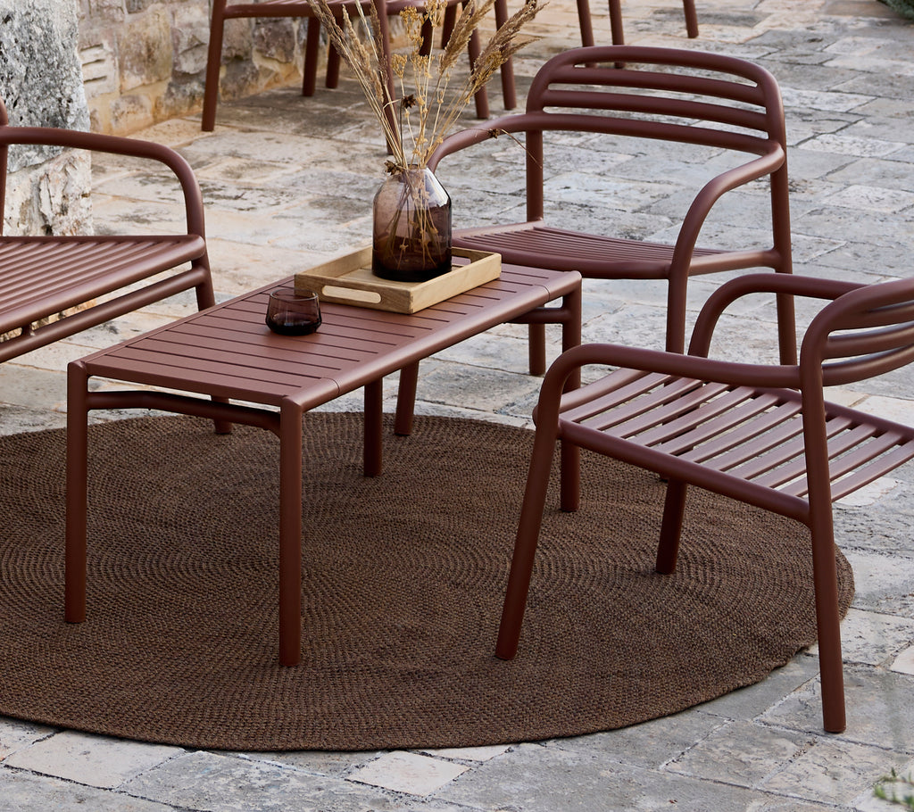 Minimalist brown table and chairs arranged in a lounge setting.