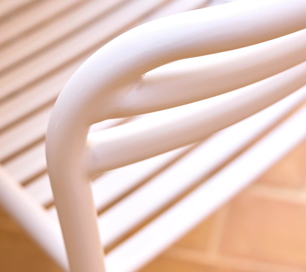 Close-up of a sand-colored dining chair showcasing smooth, curved lines and a sleek design, emphasizing modern style and comfort.