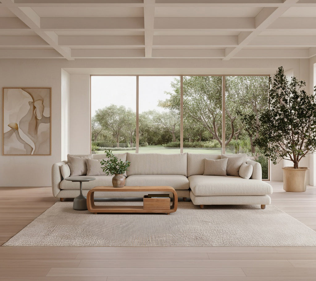 Modern lounge featuring a beige sofa, wooden coffee table, and a green plant.