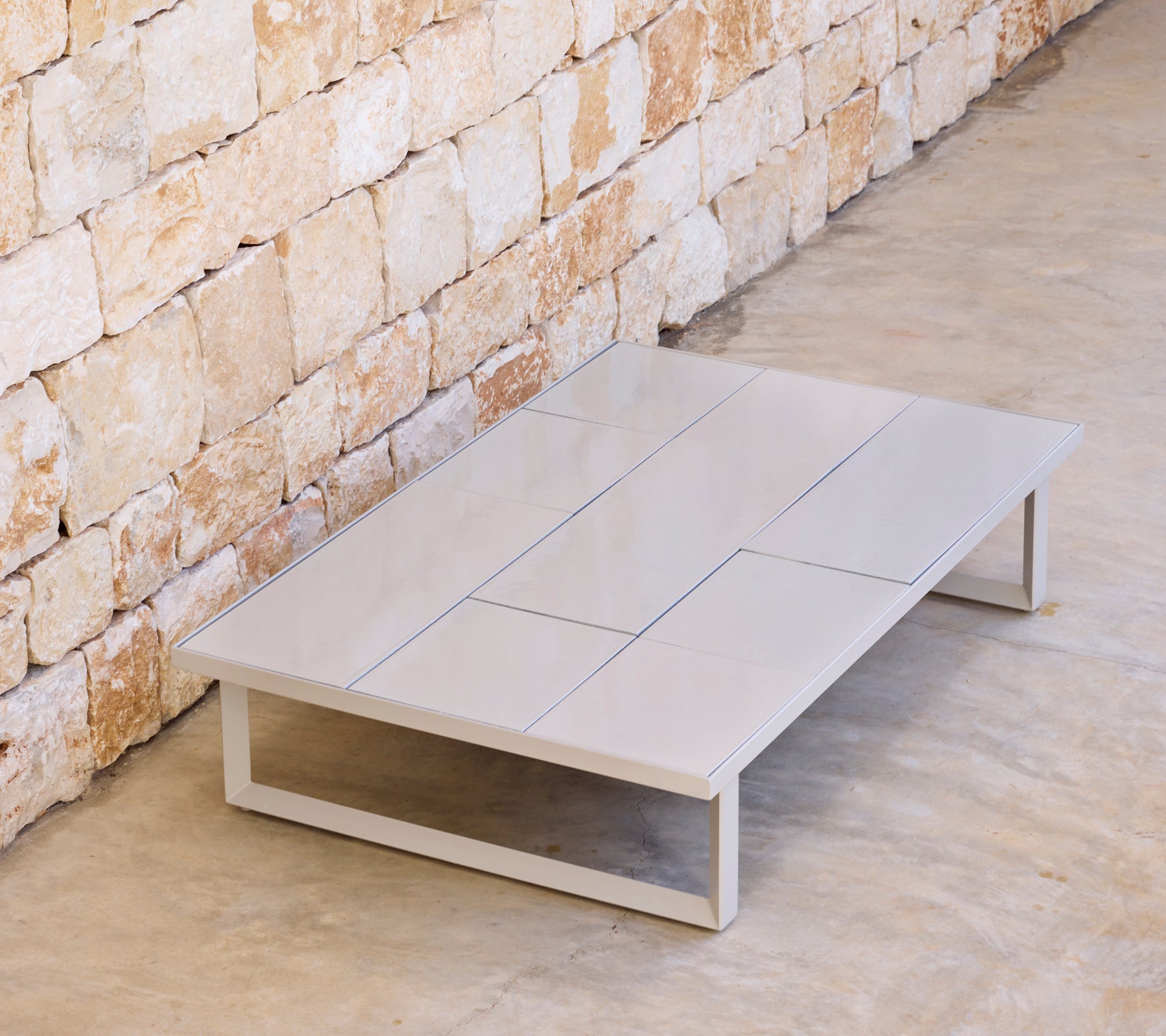 Modern grey coffee table with a minimalist design in a natural setting.