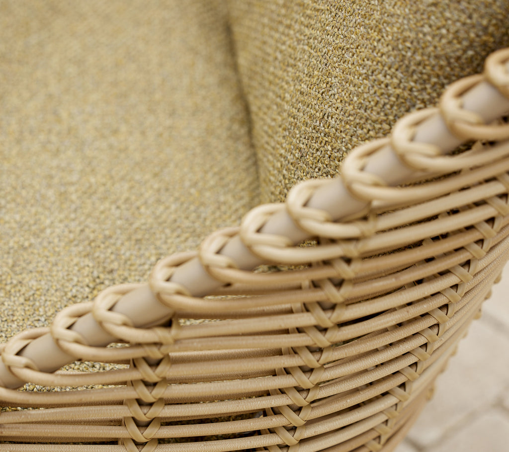 Close-up of the Hive lounge chair showcasing its woven design and textured fabric in a natural color.