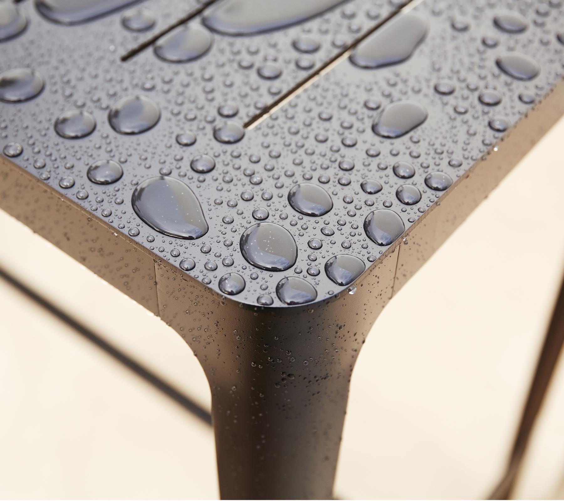 Close-up of a textured surface with water droplets, highlighting the sleek design and detailing of the material.