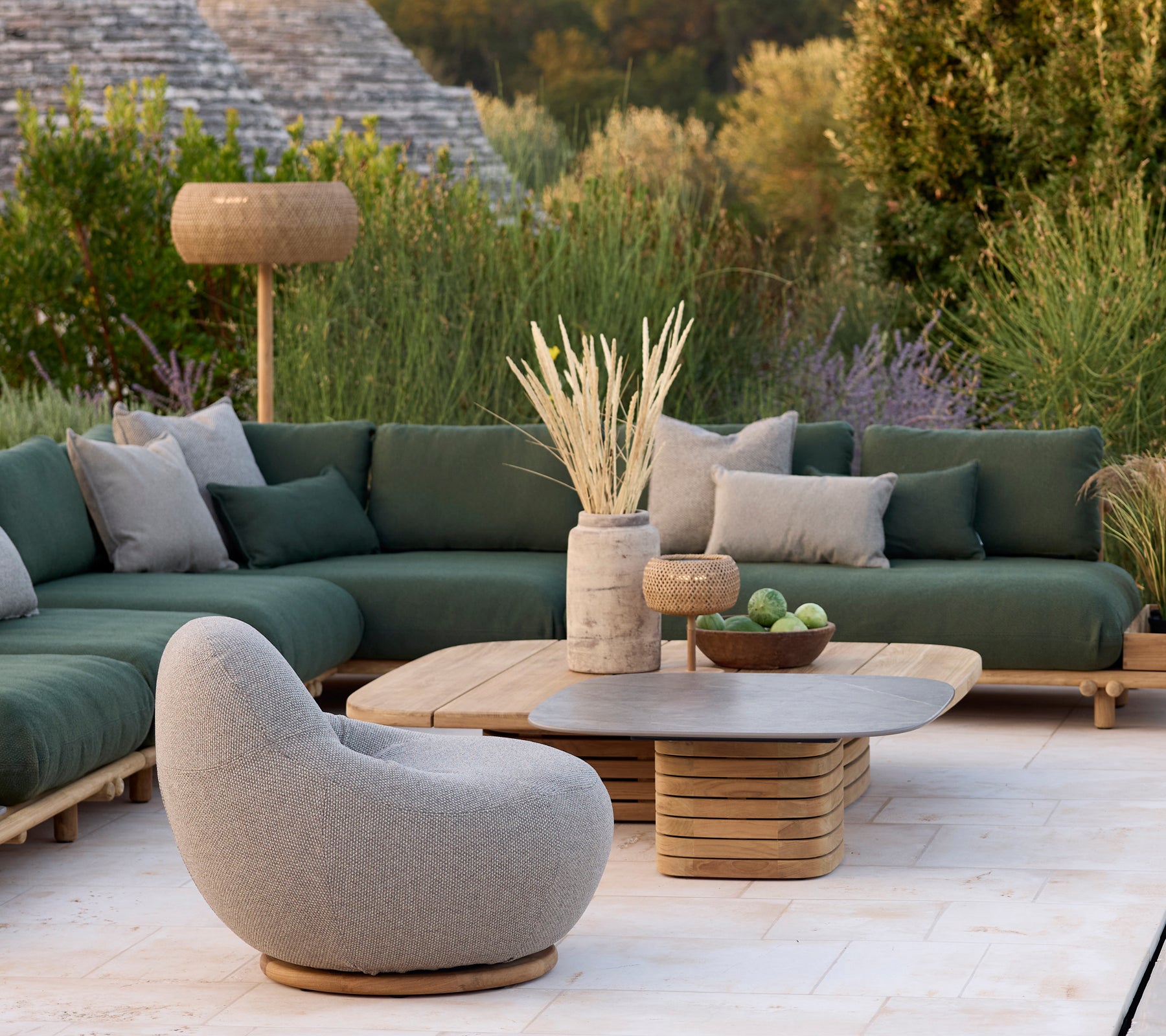 Modern lounge area with a green sofa, grey chair, and round coffee table.