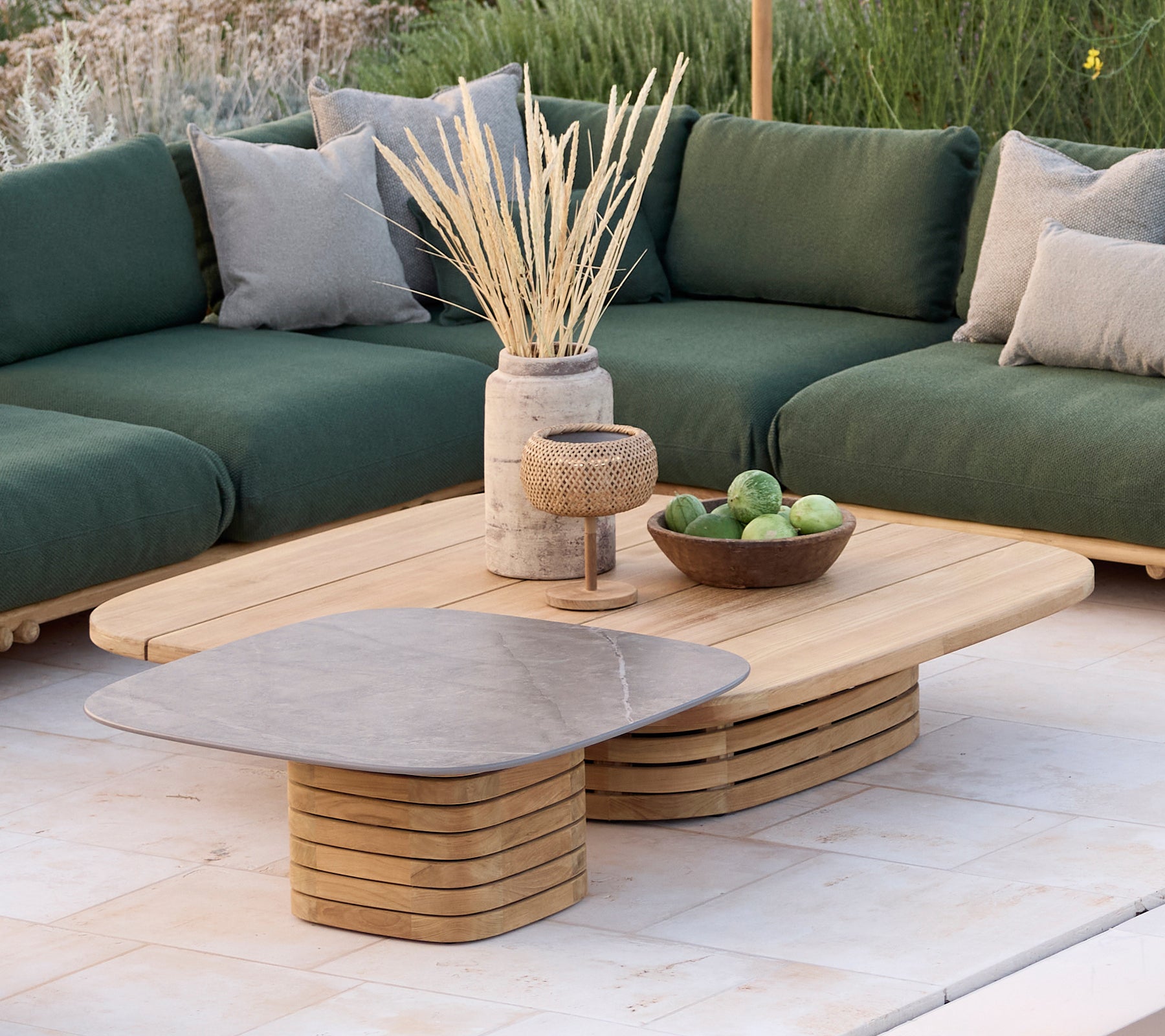 Modern lounge area featuring a green sofa with cushions, a wooden coffee table, and decorative items.