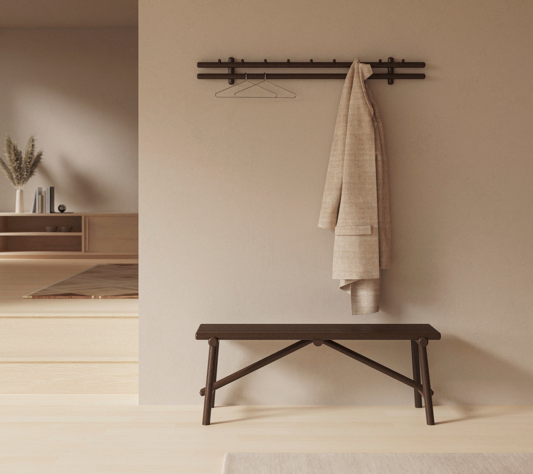 A dark wooden bench with a large rag draped over it, and a wall-mounted rack holding a hanger, set against a neutral backdrop.