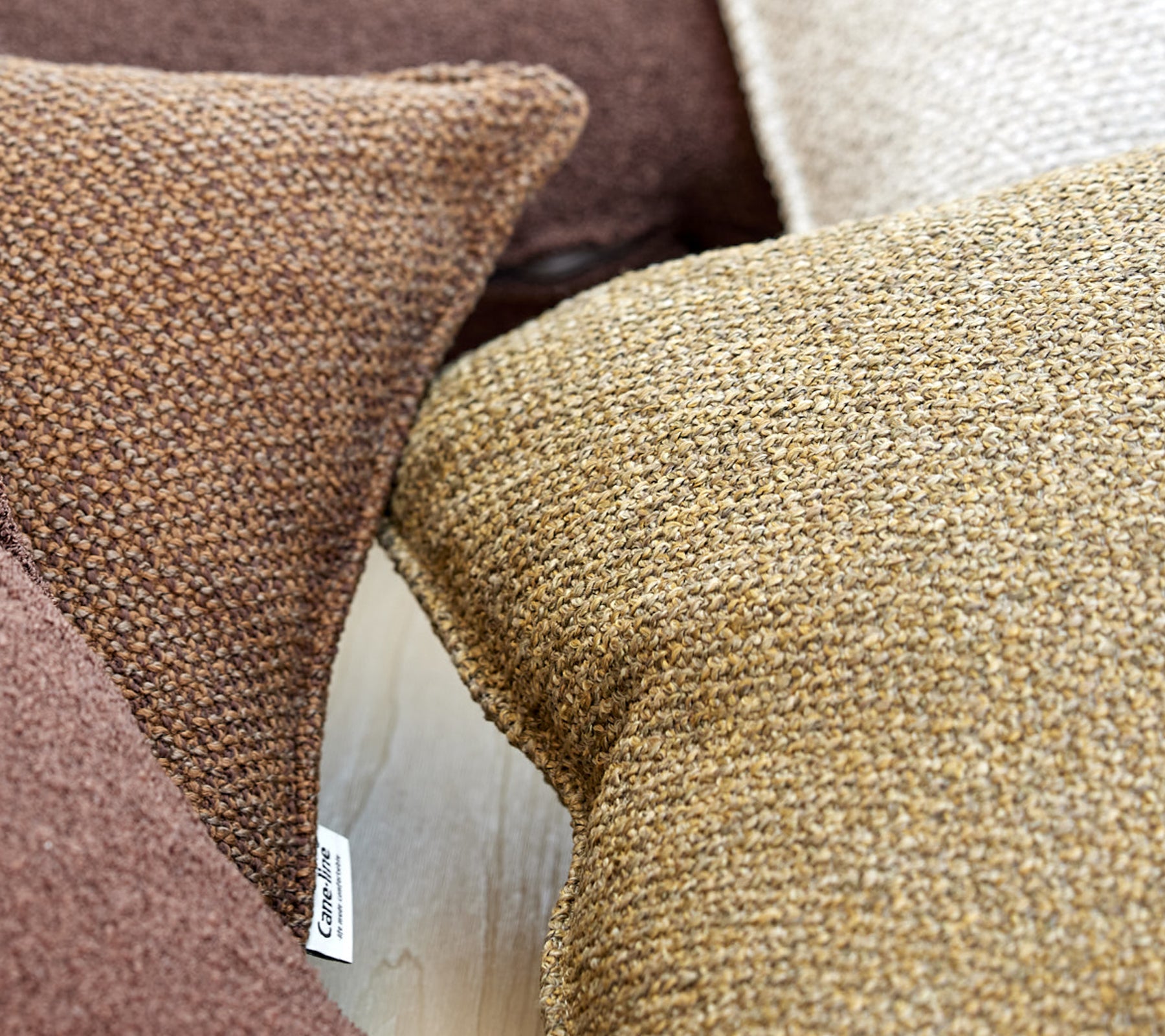 A close-up of textured cushions in various shades of brown, adding warmth and comfort to the surrounding space.